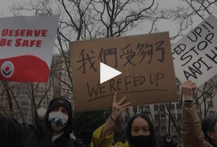 Still from Democracy Now! broadcast showing demonstrators holding signs reading: We deserve to be safe; We're fed up; Stop AAPI Hate